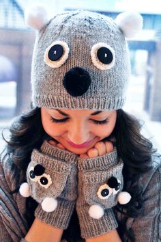 a woman wearing mittens and holding her hands to her face