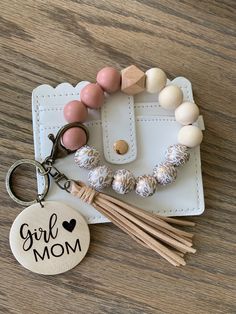 a keychain with a tassel and some beads on it that says girl mom