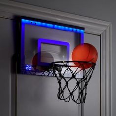 a basketball is in the hoop with an illuminated backboard on it's side