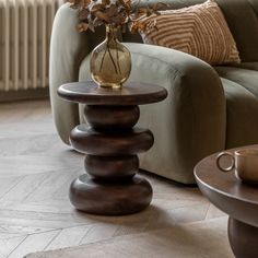 a vase with flowers sitting on top of a table next to a couch in a living room