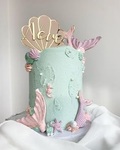 there is a blue cake with pink and green decorations on it