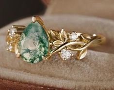 a close up of a ring with a green and white stone in it's center