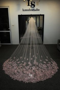 a wedding veil hanging from the ceiling in front of a door with flowers on it