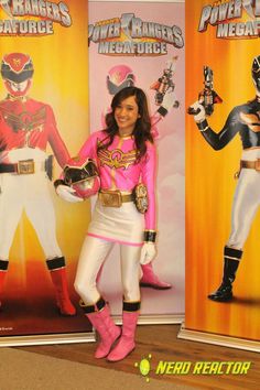 a woman standing in front of two power rangers banners