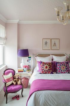 a bedroom decorated in pink and white with a teddy bear sitting on the chair next to the bed