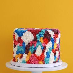 the cake is decorated with multicolored knits and has an interesting pattern on it