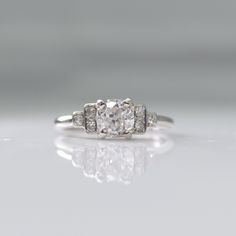 three stone diamond ring in white gold with diamonds around the band and sidestones on each side