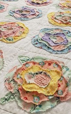 a quilted table cloth with flowers and leaves on it, all in pastel colors