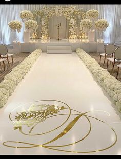 the aisle is decorated with white flowers and gold trim