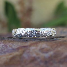 a silver ring sitting on top of a rock