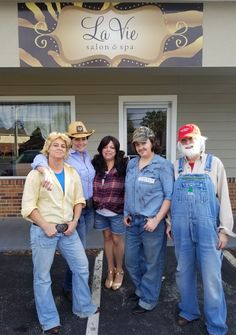 four people in overalls and cowboy hats posing for a photo outside the salon & spa