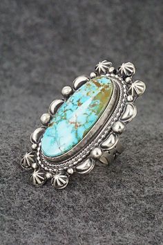 This beautiful Kingman turquoise and sterling silver ring was made by Navajo silversmith Tom Lewis. The back is signed and stamped sterling.Size: 7.5Length: 2"Width: 1 1/8"Free shipping on all orders! We ship with USPS and always include tracking. All orders ship within a day of payment.Returns are accepted up to 30 days after you receive your order. Just send us a message. Our shop offers cash back or store credit. The item must be returned in new condition. Sterling Silver Turquoise Concho Ring, Western Sterling Silver Turquoise Concho Ring, Western Sterling Silver Turquoise Ring With Patina, Western Silver Turquoise Ring Stamped 925, Silver Oval Turquoise Ring With Concho Detail, Silver Oval Turquoise Ring With Concho, Southwestern Style Large Turquoise Ring For Anniversary, Southwestern Style Large Stone Turquoise Ring For Anniversary, Southwestern Silver Turquoise Ring With Concho