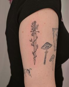 a woman's arm with tattoos on it, including mushrooms and a knife in the middle