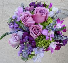 a bouquet of purple flowers sitting on top of a table