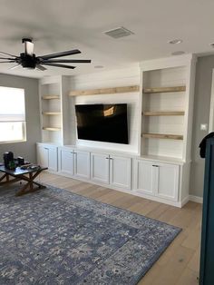 a living room filled with furniture and a flat screen tv mounted to the wall above it