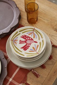 plates and glasses on a wooden table with red plaid placemats in the foreground