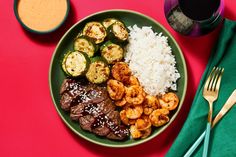 a green plate topped with meat, rice and veggies next to a cup of coffee