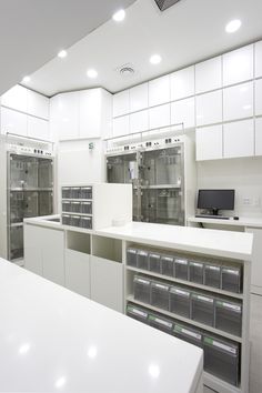 an empty white room with lots of cabinets and drawers on the wall, along with other appliances