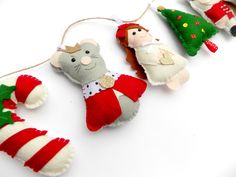 three christmas ornaments hanging from strings on a white surface with red and green trimmings