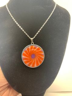 A very nice pinwheel designed necklace. It's colors are orange, purple and a little white. It was cut off an acrylic block and turned down on a lathe. It was given a high polish finish. A very unique concave design pattern. It hangs from a 21 inch chain. The pendant / bezel is 35 mm in size. Tree Pendant, Pearl Pendant Necklace, Pearl Pendant, Necklace Etsy, Necklace Lengths, Pattern Design, Jewelry Necklace Pendant, Handmade Items, Etsy Gift Card