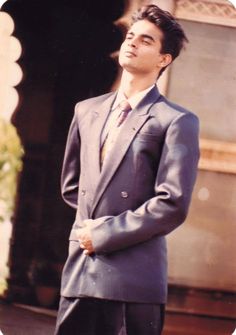 a man in a suit and tie standing outside