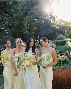 the bridesmaids are all dressed in yellow dresses and holding their bouquets together