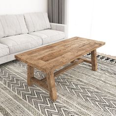 a wooden table sitting on top of a rug next to a white couch in a living room