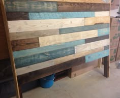 a wooden headboard made out of different colored wood planks in a workshop area