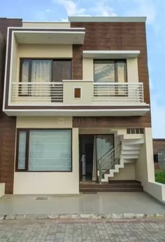 the front of a two story house with stairs leading up to it's second floor