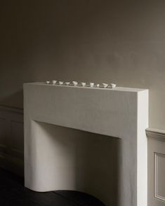 a white fireplace with candles sitting on top of it