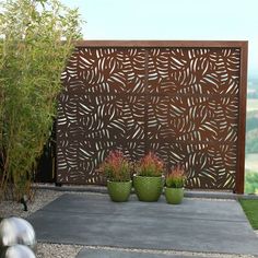 two green planters sitting in front of a wooden fence