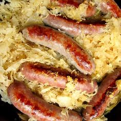 three sausages on sauerkraut in a pan