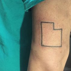 a person's arm with a small square tattoo on the left side of their arm