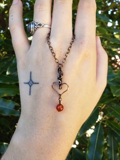 Heart pendant hand-wrapped with pure copper wire accented with a Carnelian bead. This pendant is oxidized and polished for an antiqued look, and coated with a tarnish resistant lacquer, meaning it will not brown further and will retain its shine. The tarnish resistant coating also protects from greenish coloration of the skin that comes with bare copper wire. Pendant comes with a complimentary 45cm copper plated chain which is removable and interchangeable. Check out my Instagram to see more of my work: @violet.designsnz Copper Heart Pendant For Jewelry Making, Handmade Copper Heart Pendant Jewelry, Bohemian Wire Wrapped Heart Pendant Jewelry, Bohemian Heart-shaped Copper Jewelry, Bronze-colored Copper Heart-shaped Jewelry, Hand Forged Carnelian Jewelry As Gift, Hand Forged Carnelian Jewelry For Gift, Brown Heart-shaped Spiritual Jewelry, Sterling Silver Gemstone Necklace