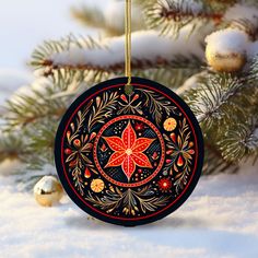 a christmas ornament hanging from a tree in the snow