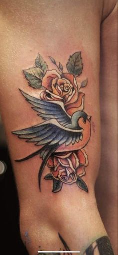 a tattoo on the side of a woman's stomach with roses and a bird