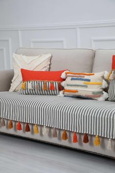 a striped couch with tassels and pillows on it