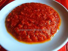 a white plate topped with sauce on top of a red table