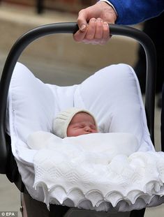 a baby in a stroller being held by a man's hand as he holds it