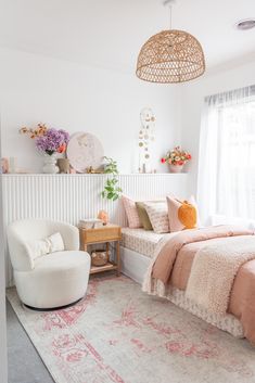 a bed room with a neatly made bed next to a chair and a rug on the floor