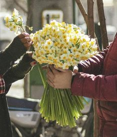 two people are holding flowers in their hands