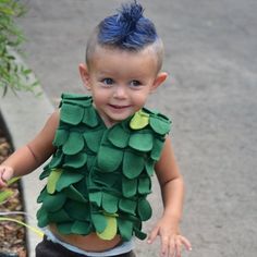 a young boy wearing a green leafy costume