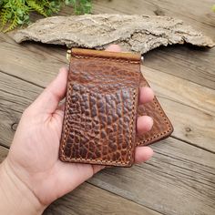 This full-grain leather Bar Clip Wallet is a great addition to your leather collection. It is now our best-selling wallet. It is made in a minimalist style and will fit nicely in your front pocket. This wallet will nicely hold a dozen bills and comes with an ID pocket, and 3 additional card pockets. These wallets come in several colors and leather hide options. All these leathers are full-grain leather and will age and patina nicely over time. *If you want this personalized with a name, initials, or a logo please add this Add-on Engraving Service to your order. Please leave a note at checkout with the name or initials. Email your logo to info@lazy3leatherco.com Specifics: 4 3/8" W x 2 3/4" H Due to the nature of tanning, the leather for these wallets will vary slightly in color and can be Classic Leather Wallets With Key Clip, Brown Leather Wallet With Key Clip, Brown Rectangular Wallet With Key Clip, Everyday Cognac Bifold Wallet, Brown Bifold Wallet With Key Clip, Rectangular Cognac Wallets With Coin Pocket, Brown Rectangular Card Holder With Key Clip, Rectangular Cognac Wallet With Coin Pocket, Brown Wallets With Key Clip For Everyday Use