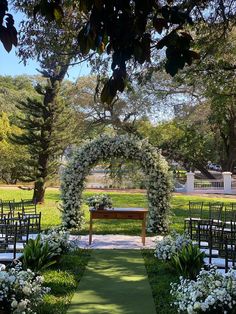 an outdoor ceremony setup with white flowers and greenery