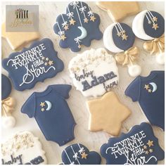 decorated cookies are arranged in the shape of baby's bodysuits and stars