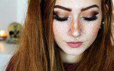 a woman with long red hair and piercings on her nose is looking at the camera