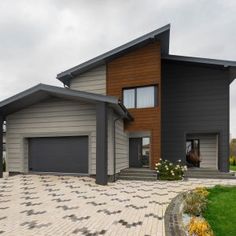 a large house with two garages on the front and side of it, surrounded by green grass