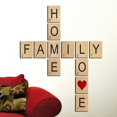 scrabble tiles spelling the word family love on a red couch in front of a white wall