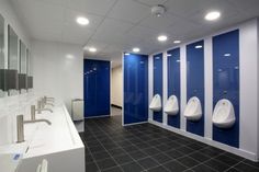 a row of urinals in a bathroom with blue and white walls