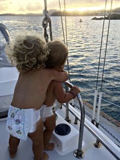 two children on a boat looking out at the water